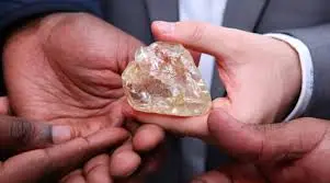 Rough uncut diamond held in the hand